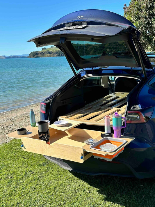 Enhance your Tesla Model Y adventures with our ergonomic camping platform bed. Easy setup, full storage access, mini kitchen, and customizable options await!