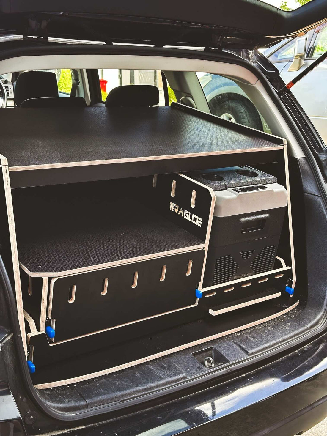 Teraglide compact kitchen module set up in the trunk of a vehicle, showcasing organized storage and cooking surface.