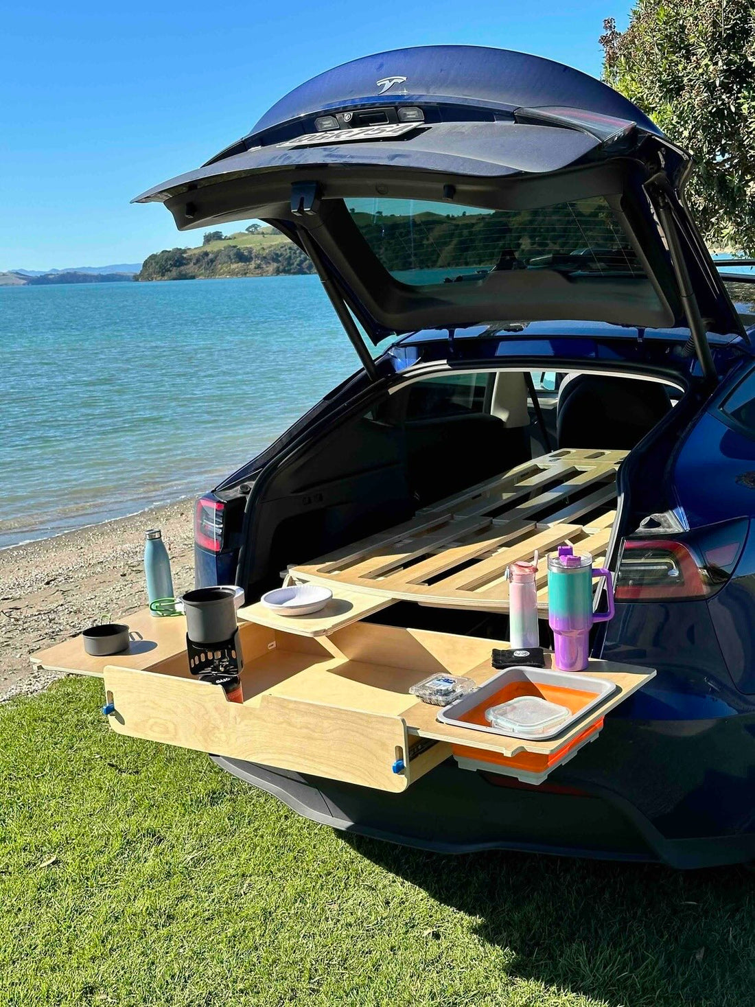Enhance your Tesla Model Y adventures with our ergonomic camping platform bed. Easy setup, full storage access, mini kitchen, and customizable options await!