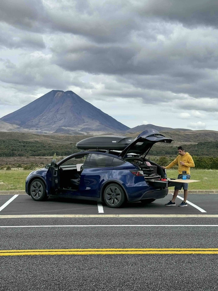 Car parked at a quiet US campsite with a Teraglide car camping platform set up in the trunk, bedding ready and camping gear neatly stored underneath