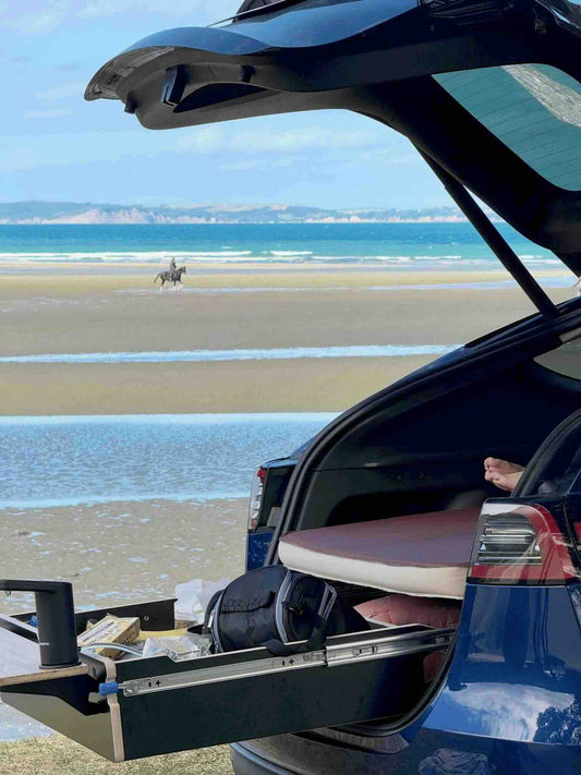 Car interior with Teraglide car camping platform set up as a flat bed, parked facing distant mountains on a calm weekend trip