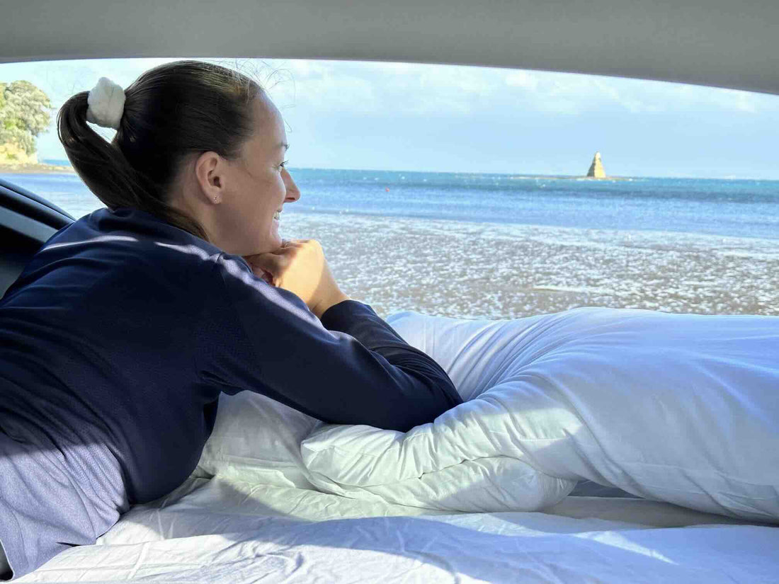 Tesla by a lake with a Teraglide car camping platform set up in the trunk, ready for a one-night micro-adventure