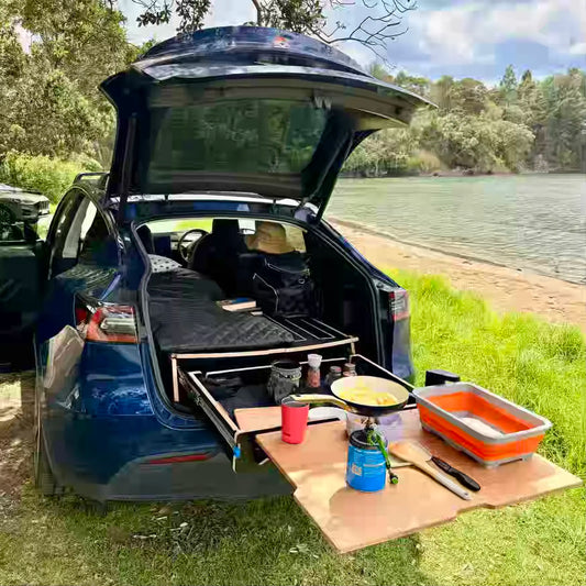 Teraglide PRO camping platform set up in a Tesla Model Y with bamboo table extended for easy cooking and storage access
