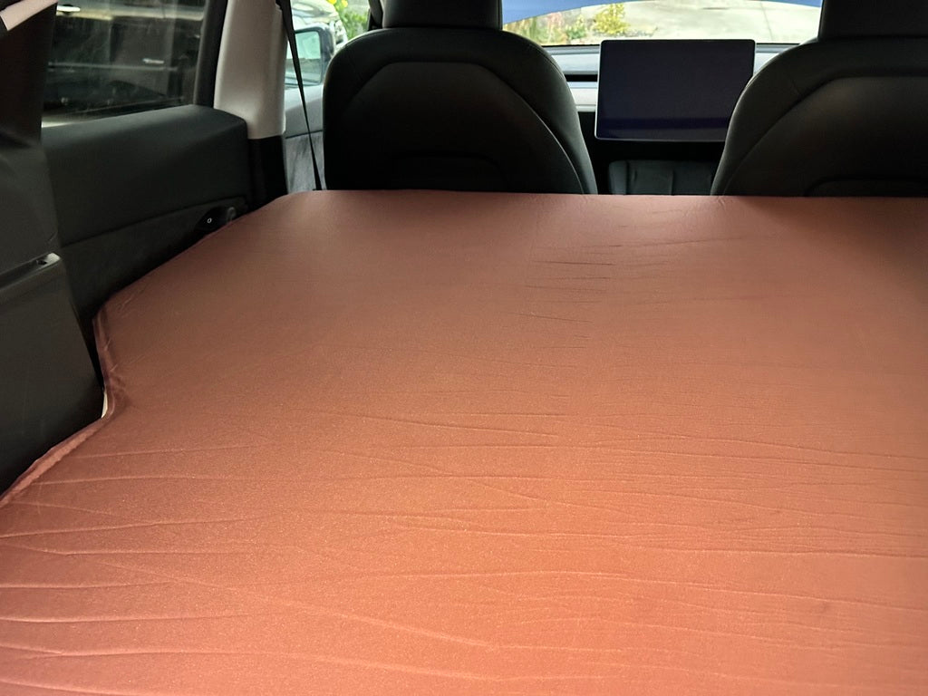 Comfortable self-inflating foam mattress for car trunks. Memory foam design for road trips and camping. Compact storage in a travel bag.