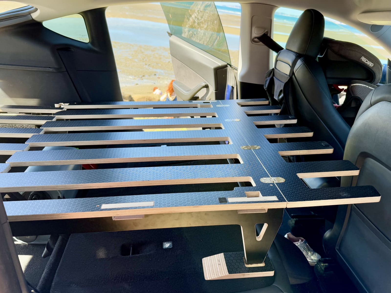 Tesla Model Y car-camping platform set up for sleeping inside the car, flat and secure.