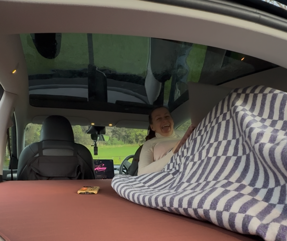 Inside Tesla Model Y with mattress on Teraglide platform for comfortable sleep.
